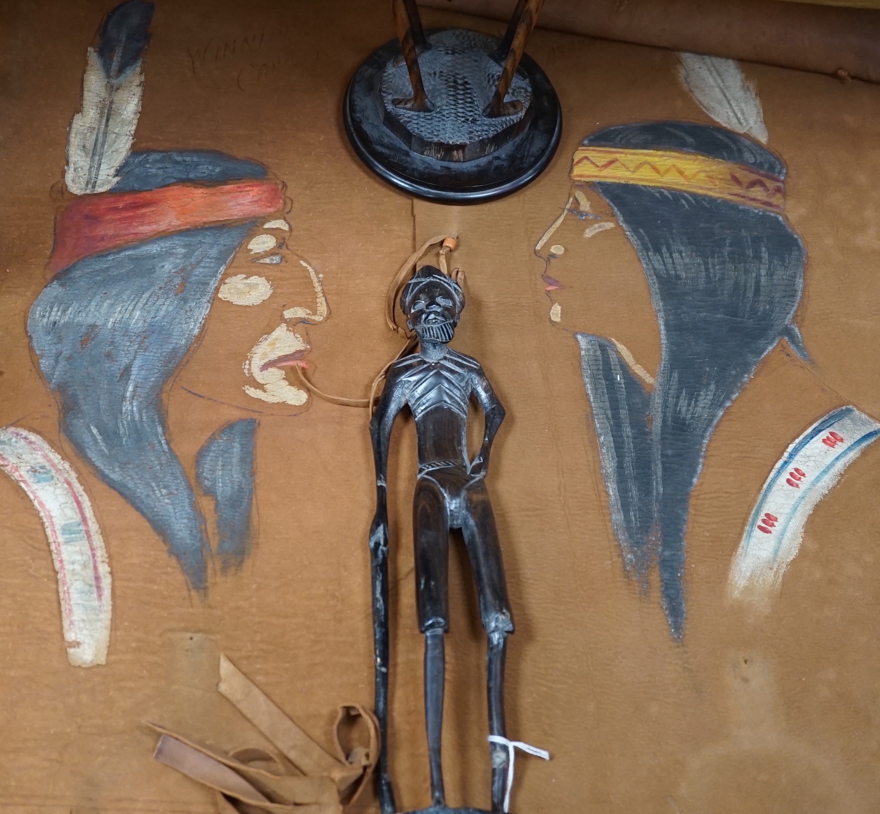 Two Native American paintings on leather and two carved hardwood figures, tallest hardwood figures 40cm high